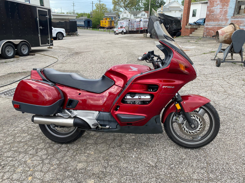 Red Honda ST1100 sport-touring motorcycle with hard bags